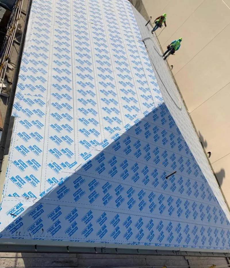 Professional roofers installing underlayment on a metal roof in Westphalia